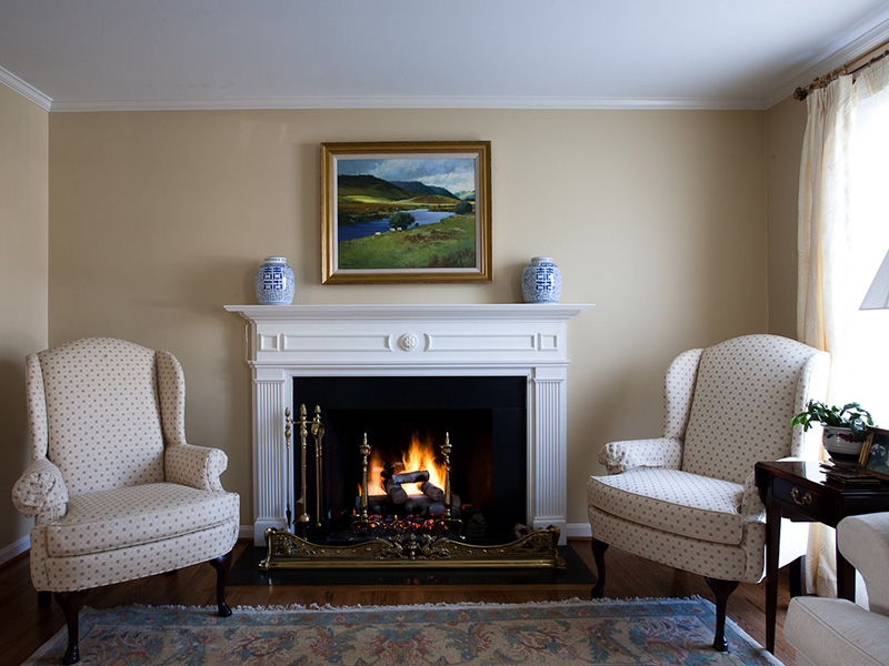 room with fireplace and white chairs